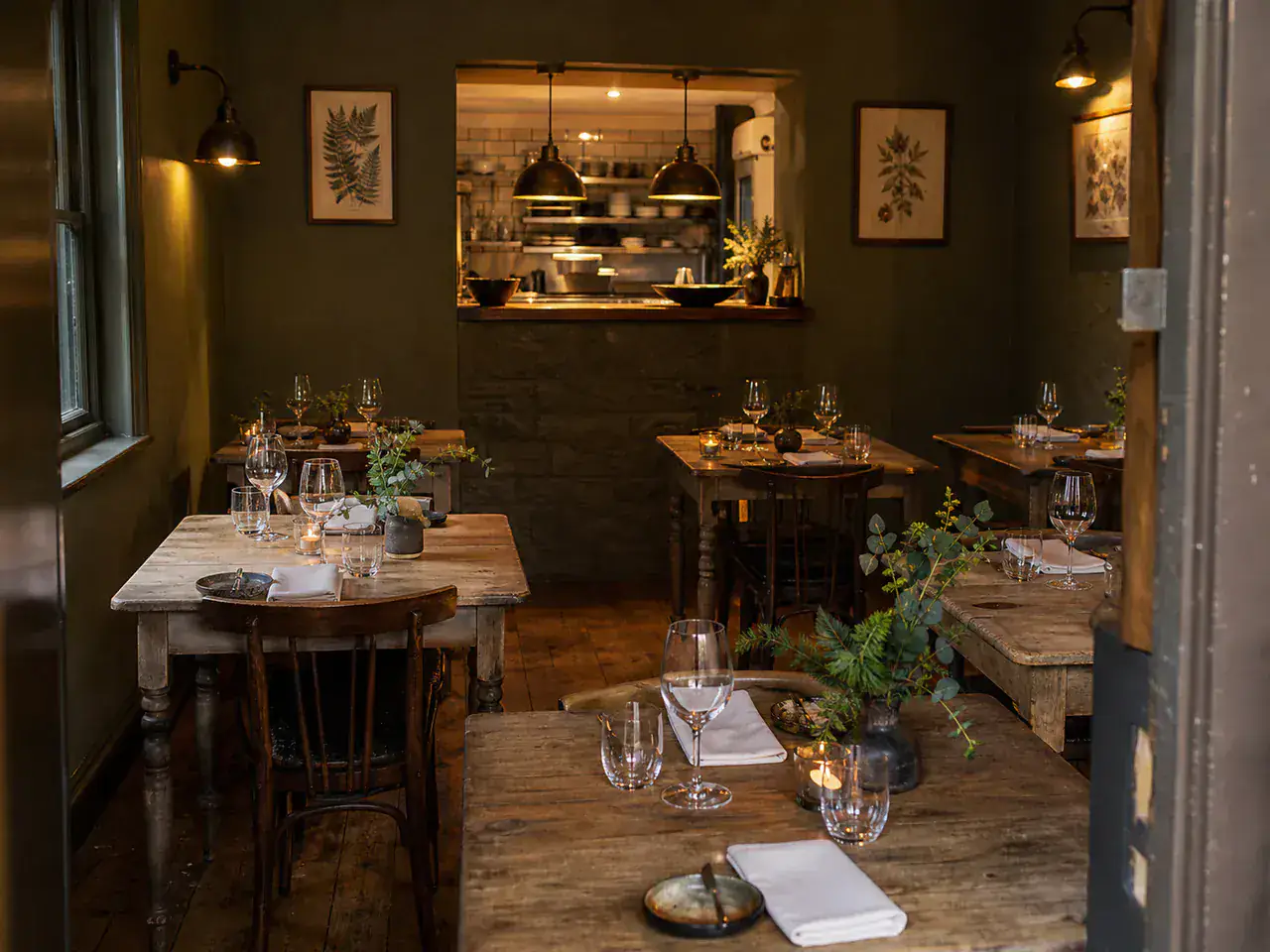 An intimate restaurant dining room with oak tables and candlelight